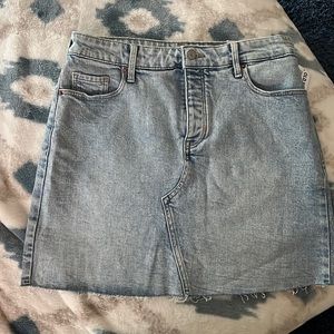 BNWT light wash denim skirt. Multiple buttons with lightly frayed bottom.